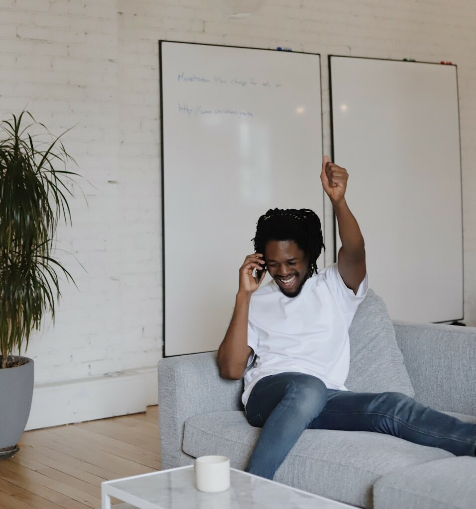 Man zittend op een bank heeft een positief telefoongesprek